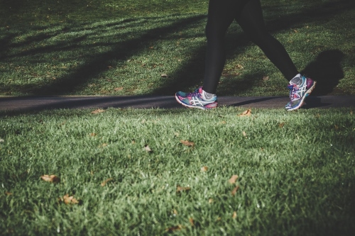 Female walking on grass in trainers 